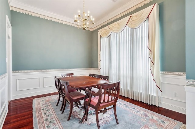 dining room with an inviting chandelier, crown molding, and dark hardwood / wood-style floors