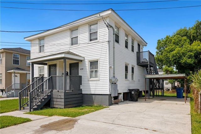 view of front of house with stairs, a porch, a carport, and driveway