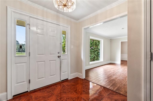 entryway featuring ornamental molding, a notable chandelier, and dark parquet flooring