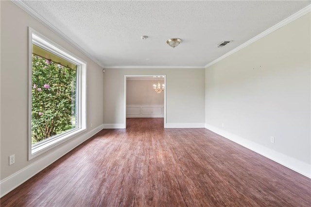 empty room with a textured ceiling, dark hardwood / wood-style flooring, an inviting chandelier, and a wealth of natural light