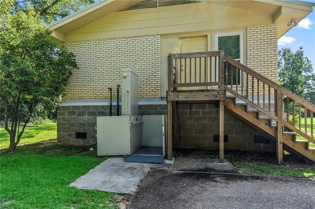 view of exterior entry featuring a lawn