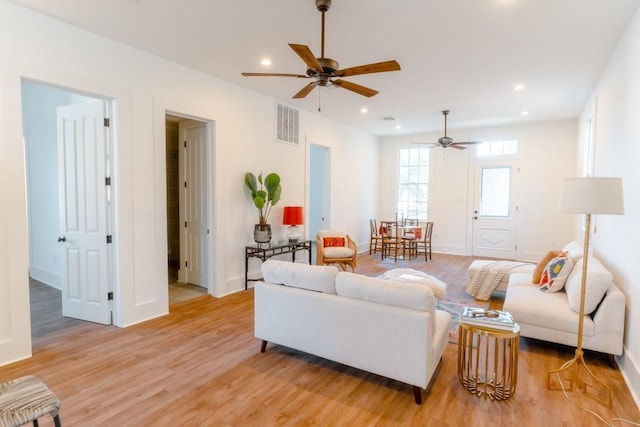 living room featuring ceiling fan and light hardwood / wood-style floors