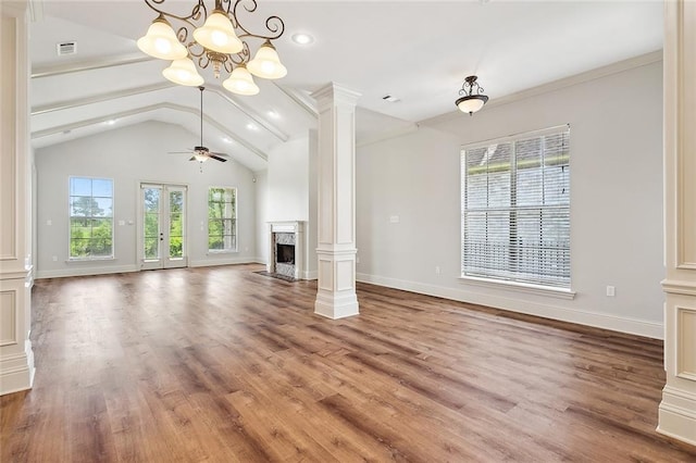 unfurnished living room featuring hardwood / wood-style flooring, a healthy amount of sunlight, a fireplace, and ceiling fan with notable chandelier