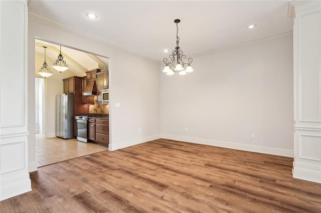 unfurnished dining area with vaulted ceiling, ornamental molding, a chandelier, and light wood-type flooring