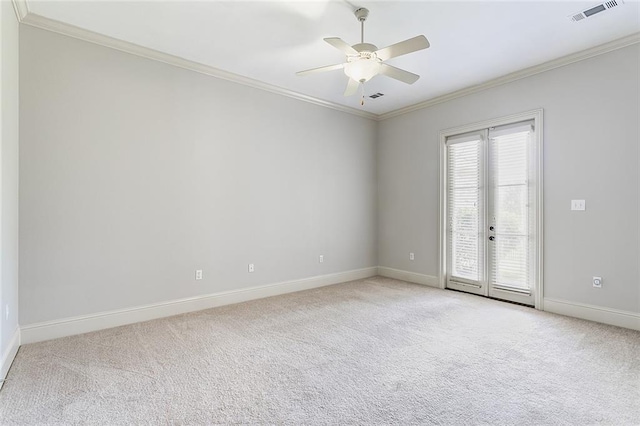 carpeted empty room with ornamental molding, ceiling fan, and french doors