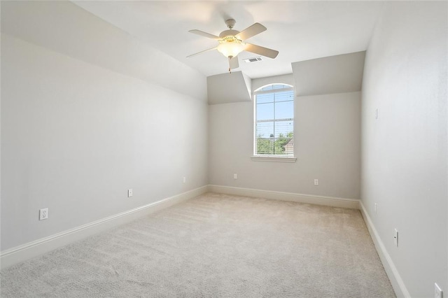 empty room with ceiling fan, light colored carpet, and lofted ceiling