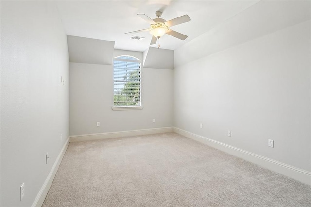 carpeted empty room with ceiling fan and vaulted ceiling