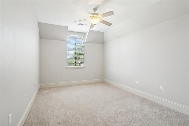 carpeted spare room with vaulted ceiling and ceiling fan