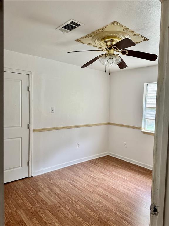 empty room with ceiling fan and hardwood / wood-style floors