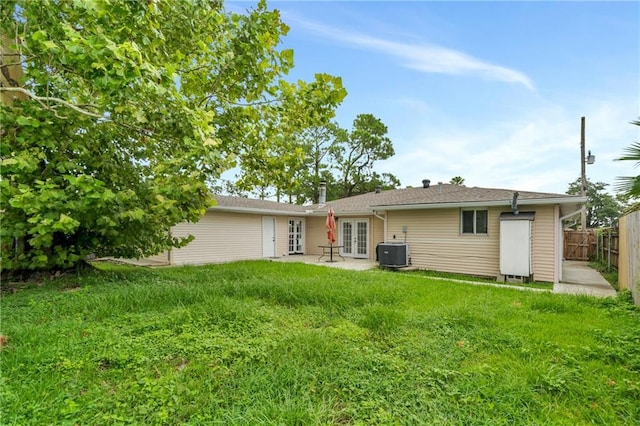 back of house with french doors, central AC, and a lawn