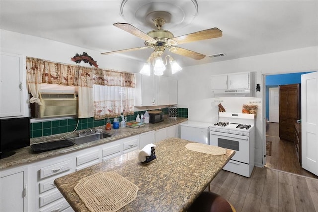 kitchen featuring sink, dark hardwood / wood-style flooring, white cabinets, and gas range gas stove