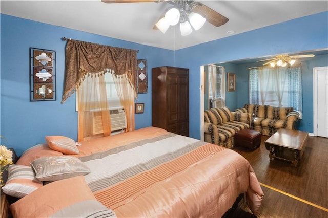 bedroom with ceiling fan, cooling unit, multiple windows, and hardwood / wood-style flooring