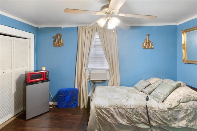 bedroom with dark hardwood / wood-style flooring, ceiling fan, cooling unit, and a closet