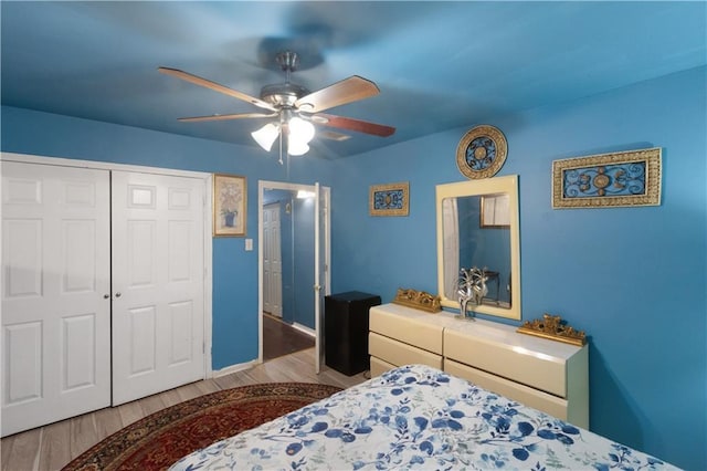 bedroom featuring ceiling fan, light hardwood / wood-style flooring, and a closet