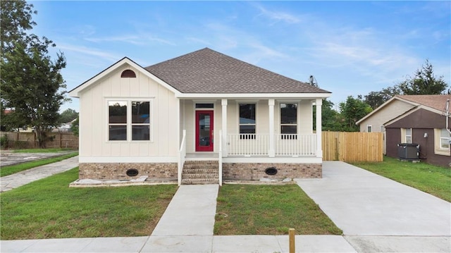 view of front of house featuring a porch, central air condition unit, and a front lawn