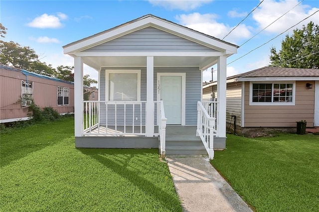 bungalow with a front lawn and covered porch