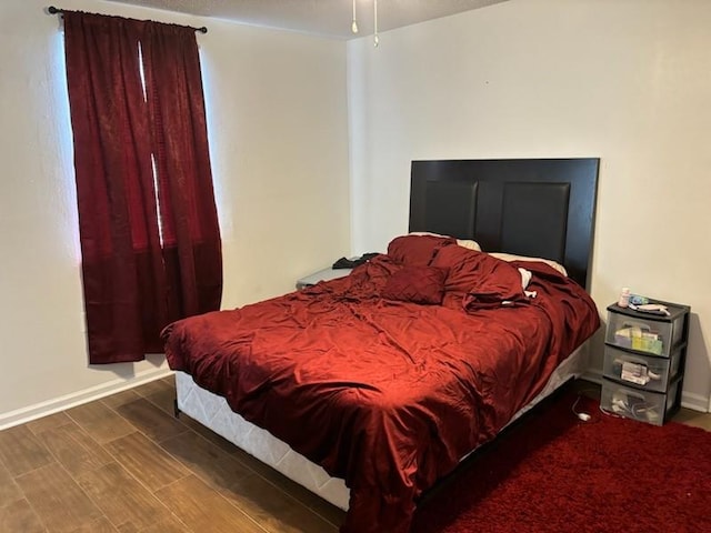 bedroom with dark hardwood / wood-style flooring