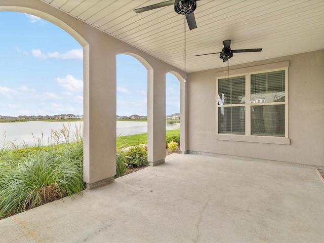 view of patio featuring a water view and ceiling fan