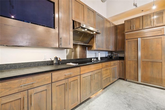 kitchen featuring black electric stovetop, paneled built in refrigerator, and range hood