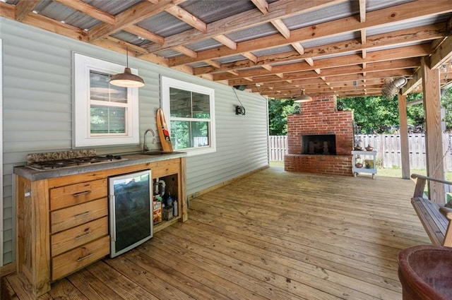 wooden deck with wine cooler and an outdoor brick fireplace