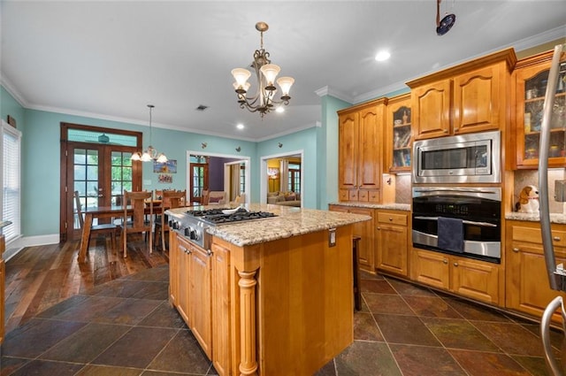 kitchen featuring appliances with stainless steel finishes, french doors, an inviting chandelier, a kitchen island, and hanging light fixtures