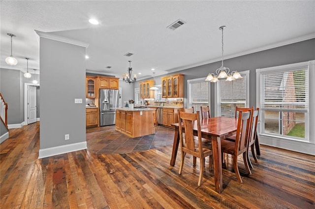 dining area with crown molding, dark wood-type flooring, and a notable chandelier