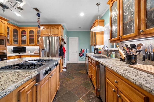 kitchen with pendant lighting, crown molding, sink, light stone countertops, and stainless steel appliances