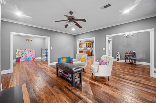 living room featuring ceiling fan with notable chandelier, dark hardwood / wood-style flooring, and ornamental molding