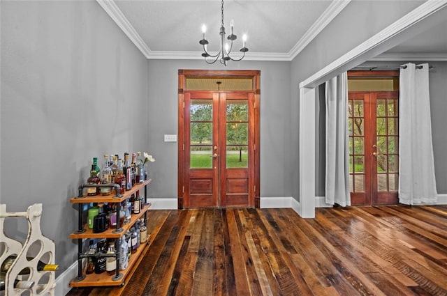 foyer with french doors, ornamental molding, and an inviting chandelier