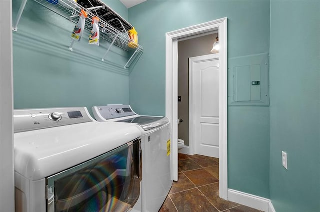 laundry area featuring separate washer and dryer, electric panel, and dark tile patterned flooring