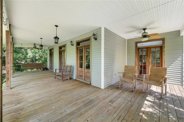 wooden terrace with ceiling fan, french doors, and covered porch