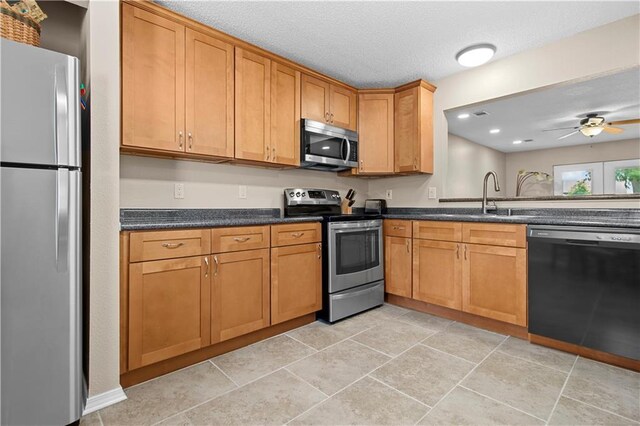 kitchen featuring sink, appliances with stainless steel finishes, ceiling fan, and light tile patterned floors