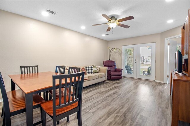 dining room featuring wood-type flooring, french doors, and ceiling fan