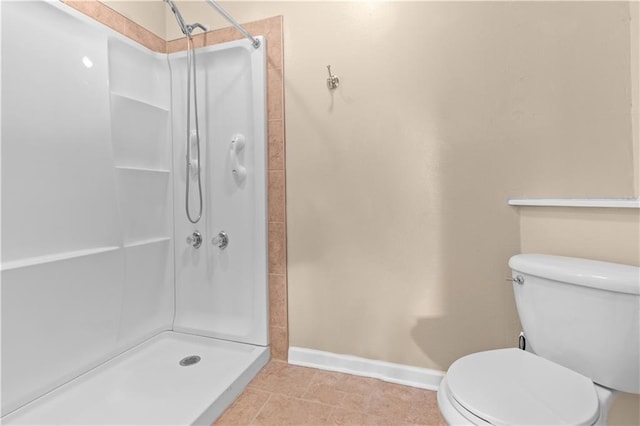 bathroom with tile patterned floors, toilet, and a shower