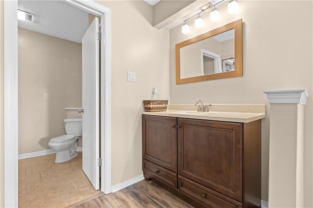 bathroom with vanity, hardwood / wood-style flooring, and toilet