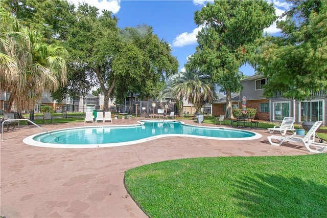 view of swimming pool featuring a lawn and a patio