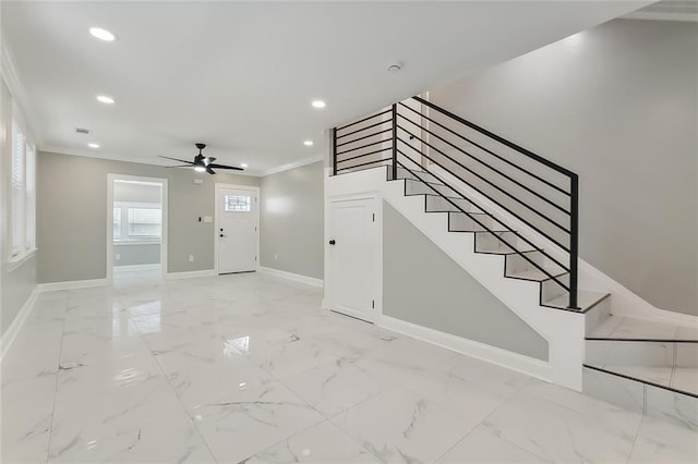 entryway with ornamental molding and ceiling fan