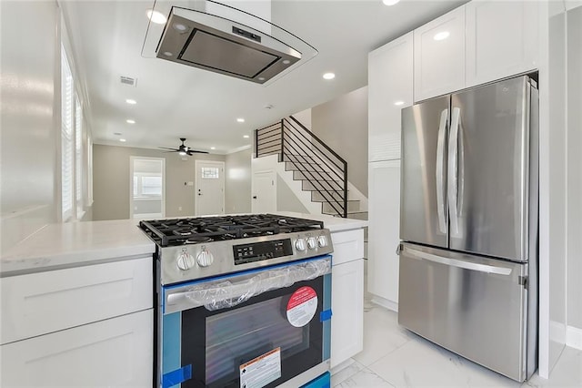 kitchen with appliances with stainless steel finishes, white cabinetry, and ceiling fan