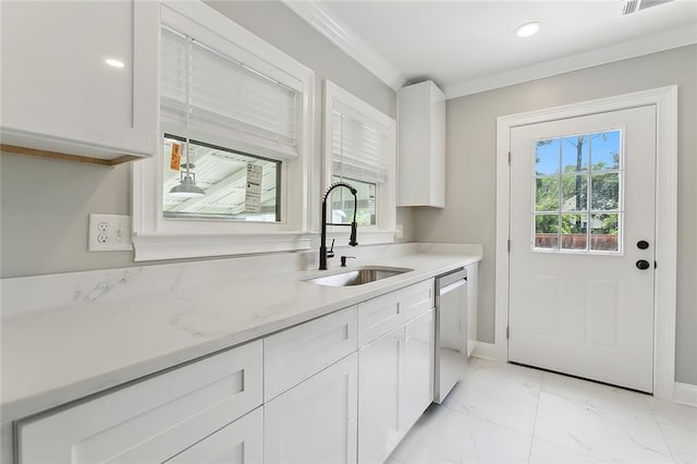 kitchen featuring stainless steel dishwasher, sink, white cabinetry, and a wealth of natural light