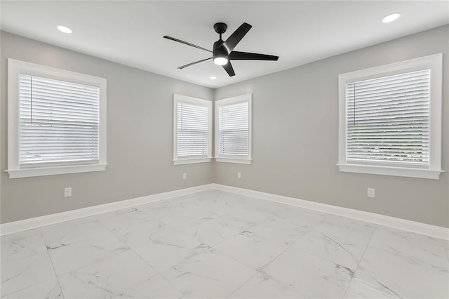 spare room featuring ceiling fan and a wealth of natural light