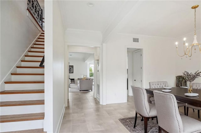 dining room with a notable chandelier, light tile patterned floors, and crown molding