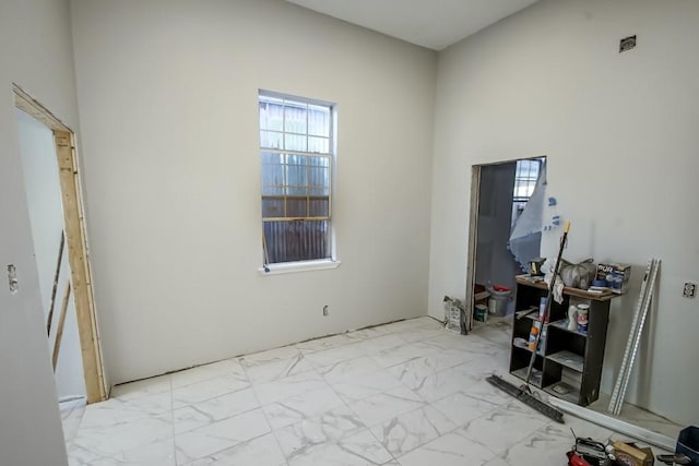 interior space with light tile patterned flooring and a high ceiling