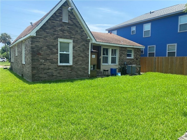 2428 Independence St, New Orleans, LA 70117 - rear view of property with central AC and a lawn