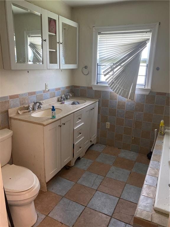 2428 Independence St, New Orleans, LA 70117 - bathroom featuring vanity, toilet, and tile walls