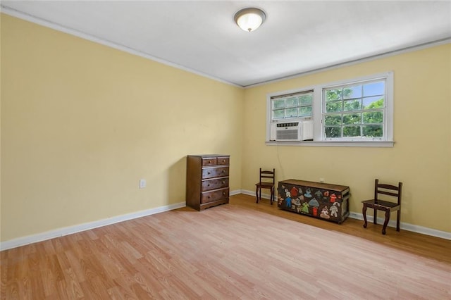spare room with baseboards, wood finished floors, cooling unit, and ornamental molding