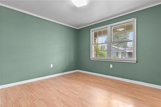 spare room with light wood-type flooring and crown molding