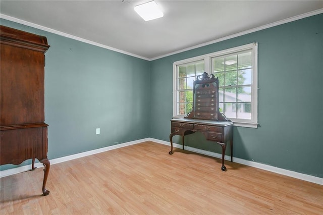 interior space with baseboards, ornamental molding, and light wood finished floors