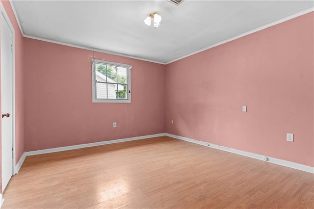 unfurnished room featuring light wood-type flooring, ornamental molding, and baseboards