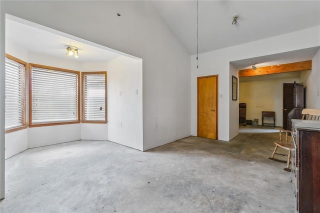 interior space with unfinished concrete flooring and lofted ceiling