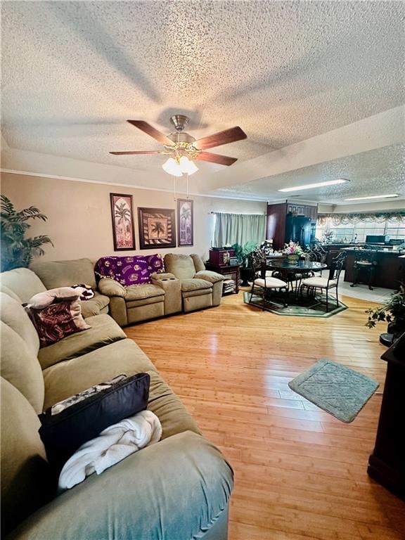 living room featuring a textured ceiling, ceiling fan, and hardwood / wood-style floors